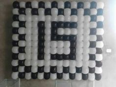 an art piece made out of black and white plastic tubes on the wall in front of a window