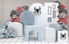 a room decorated for halloween with balloons and spider - man decorations on the wall,