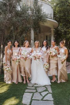 a group of women standing next to each other in front of a building