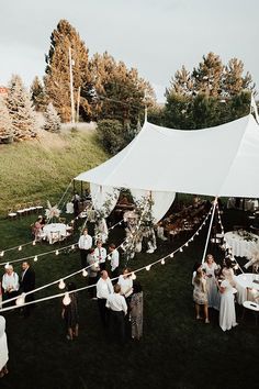 a group of people standing around a white tent