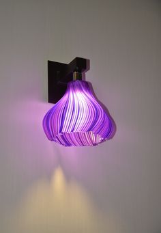 a purple light hanging from the side of a wall