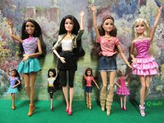 barbie dolls are lined up against a wall