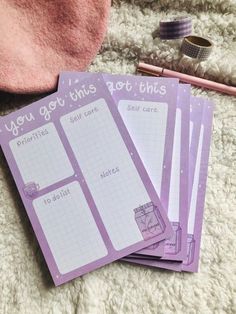 three notebooks sitting on top of a white rug next to a pen and eyeglasses