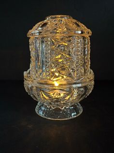 Add a touch of vintage charm to your home decor with this beautiful fairy lamp by Indiana Glass. The clear glass cylinder features a stunning stars and bars pattern that is sure to catch the eye of any admirer. Perfect for all occasions, this large lamp illuminates with a glossy finish and romantic theme. Crafted from high-quality glass materials, this fairy lamp is built to last and adds a unique touch to any room. The American style and decorative collectibles make it a great addition to any home. Get your hands on this one-of-a-kind piece today and add a touch of elegance to your living space. Fairy Lamps Vintage, Light Knight, Grandma Era, Lantern With Fairy Lights, Bars Design, Fairy Lamps, Glass Fairy, Large Lamp, Thrift Ideas