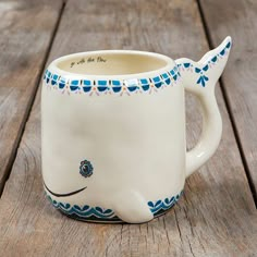 a ceramic whale mug sitting on top of a wooden table