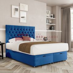 a bed with blue upholstered headboard and foot board in a bedroom setting