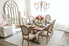 a dining room table with chairs and plates on it