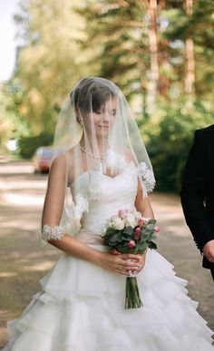 a woman in a wedding dress holding a bouquet