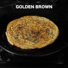 a close up of a pancake in a skillet on a stove with the words golden brown above it