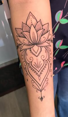 a woman's arm with a lotus tattoo on it