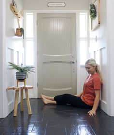 a woman sitting on the floor in front of a door