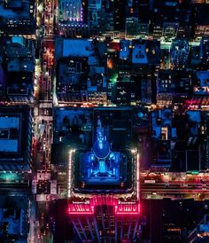 an aerial view of a city at night with lots of lights and buildings in the background