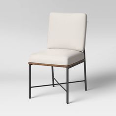 a white chair with black legs and a seat cushion on top of the armrests