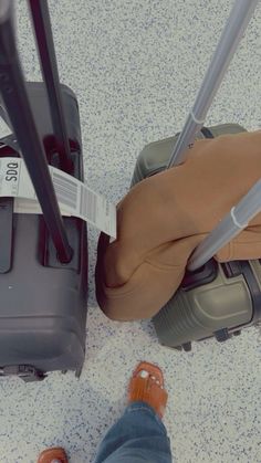 a person standing next to two pieces of luggage