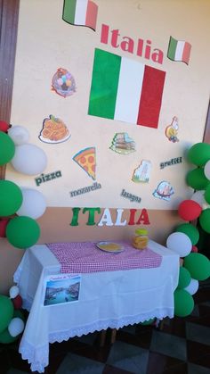 there is a table with some pizza on it and balloons in the shape of italy