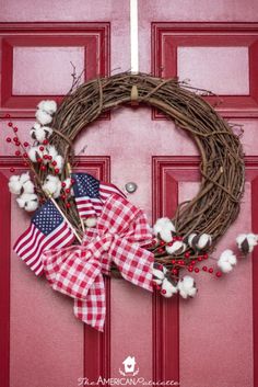 a red door with a wreath on it and the words diy farmhouse flag wreath