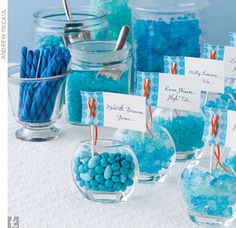 blue candies and candy in glass bowls with place cards on them for guests to sign