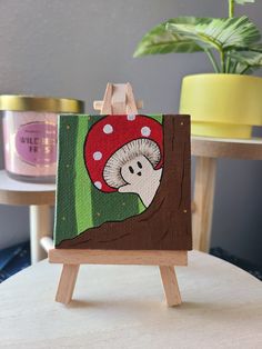 an easel with a painting of a mushroom on it