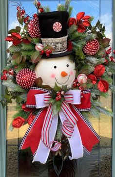 a christmas wreath with a snowman wearing a top hat