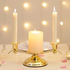 three candles are lit on a gold candelabra