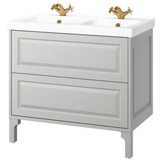 two golden faucets sit on top of a white sink cabinet with gold handles