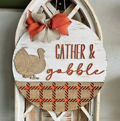 a wooden sign that says gather and gobble with a turkey hanging from the side