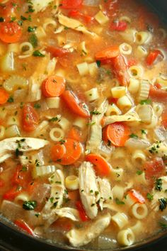 a pot filled with pasta and carrots on top of a stove