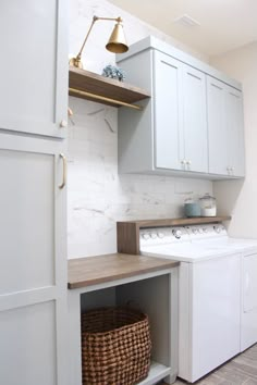 a white washer and dryer sitting inside of a laundry room next to a sink