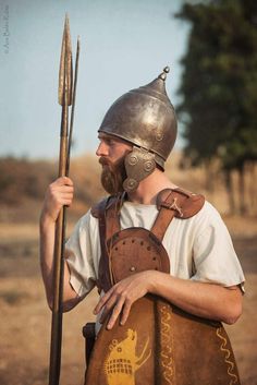 a man wearing a helmet and holding a spear