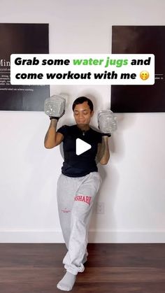 a man holding two water jugs in front of his face with the caption grab some water jugs and come workout with me