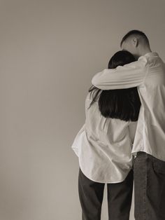 two people are hugging each other in black and white