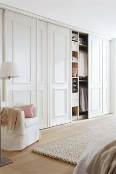 a bedroom with white closets and carpeted flooring