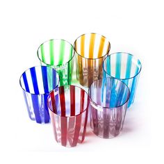 six multicolored glass cups sitting next to each other