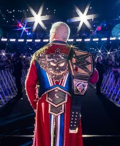 a man in a red and blue outfit standing on a stage with his back to the camera