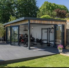 an outdoor gym with exercise equipment and potted plants