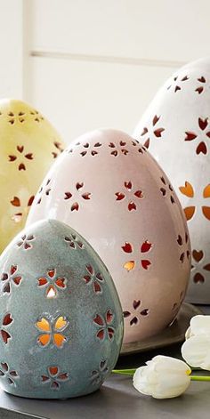 four decorative eggs sitting on top of a table