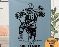 a blue wall hanging with a black and white football player on it's side