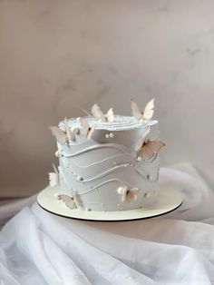 a white wedding cake with butterflies on it