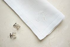 the monogrammed napkin is next to two small studs on top of it