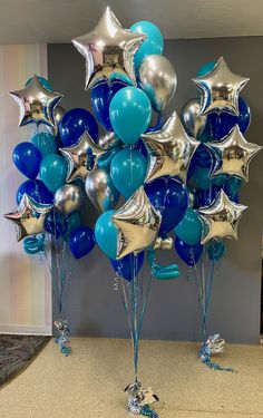 a bunch of blue and silver balloons in the shape of stars