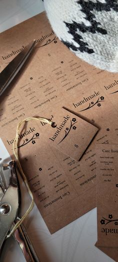 several pieces of brown paper sitting on top of a table next to scissors and thread