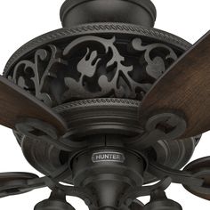 a ceiling fan with wooden blades and carved designs on the blade, in an antique style