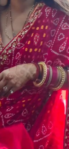 a woman in a red sari is holding something