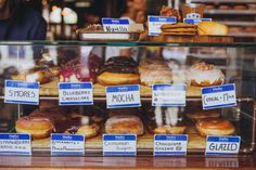 a display case filled with lots of different types of doughnuts and pastries