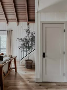 an open door in a white room with wood floors