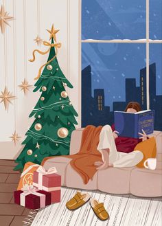 a woman laying on a couch reading a book next to a christmas tree