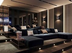 a living room filled with lots of furniture next to a wall mounted movie projector