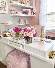 a white desk topped with lots of pink flowers