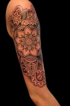 an arm with a flower tattoo on the left side of it, and a black background