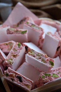 there are many pieces of pink cake in the basket on the table and one is cut into cubes